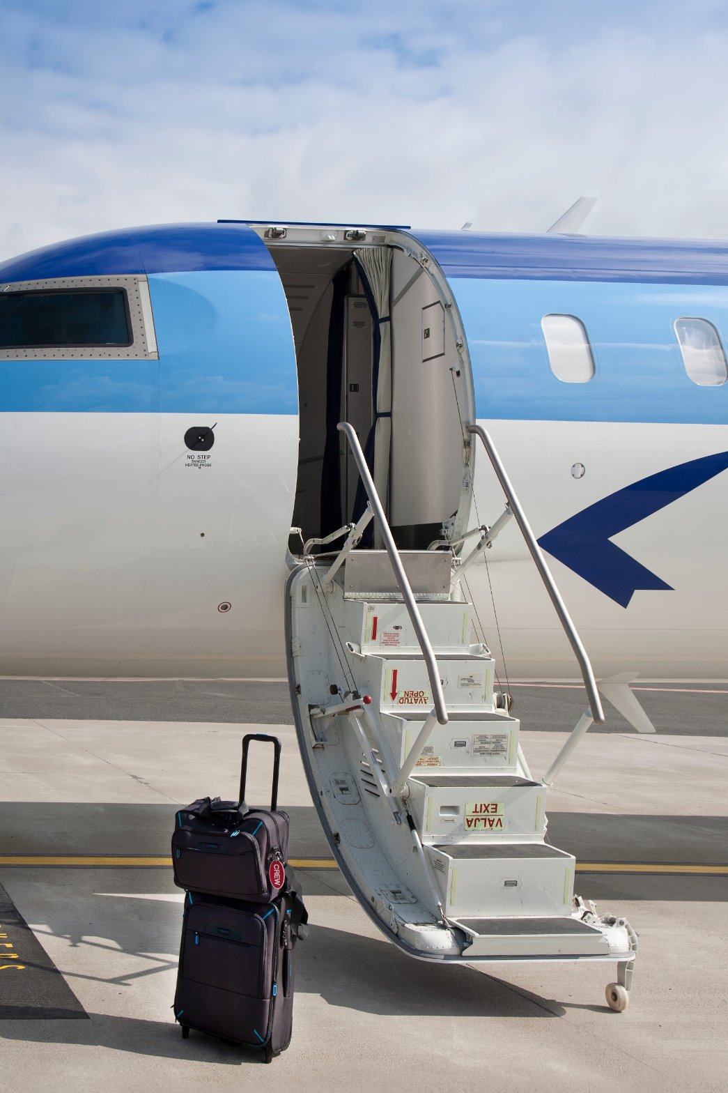 Blue and white medical flight airplane on the tarmac with luggage loaded, ready for departure